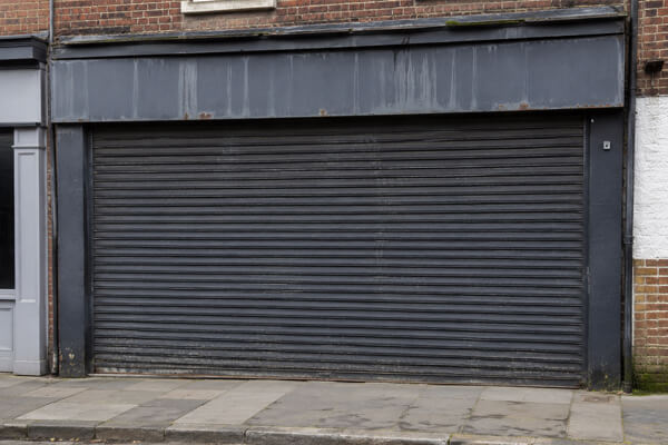 Faded roller shutter before commercial spraying in Leighton Buzzard